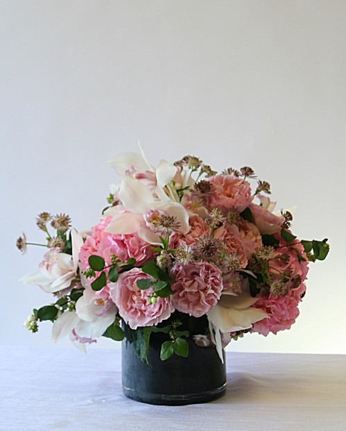 Traditional style arrangement of garden roses and orchids