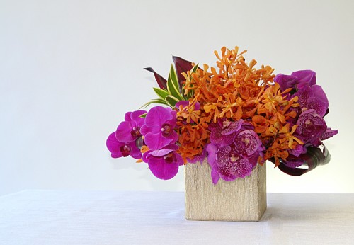 Modern style arrangement of orchids and tropical accents